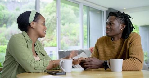 African American couple sharing warm conversation over coffee in sunlit home