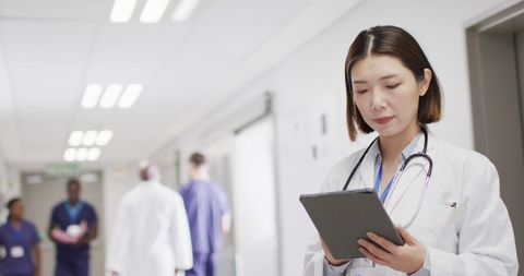 Asian Female Doctor Using Tablet in Hospital Corridor - Download Free Stock Images Pikwizard.com