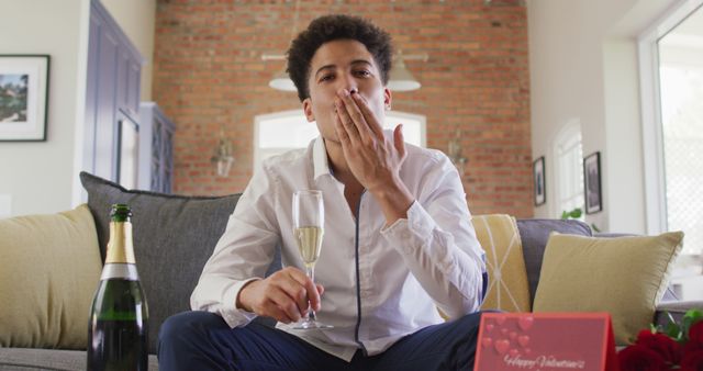 Young Man Blowing Kiss While Holding Champagne Glass at Home - Download Free Stock Images Pikwizard.com