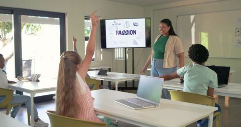 Teacher Teaching Diverse Students Using Laptops in Classroom With PASSION Presentation