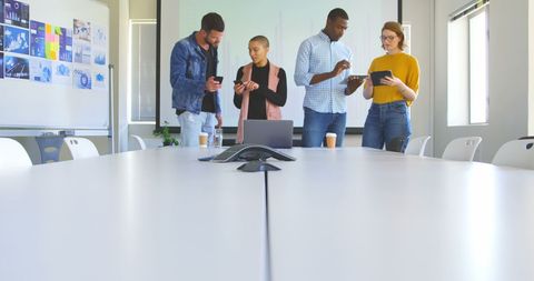 Diverse team collaborating with digital devices in office setting