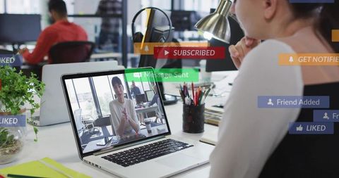 Professional woman video calling in open-plan office with social notifications overlay