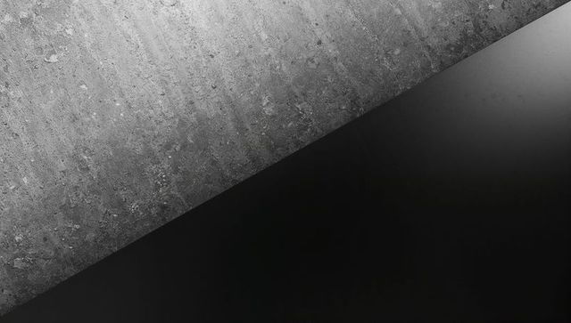 Highlighting textured concrete contrasting smooth black panel diagonal minimalist composition