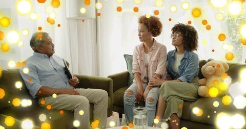 Multigenerational family sharing heartfelt conversation in cozy backlit living room
