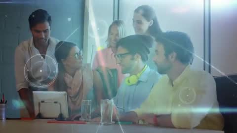 Creative team collaborating around tablet while digital analytics overlays animate across screen