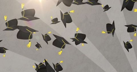 Black graduation caps flying with gold tassels over textured gray background