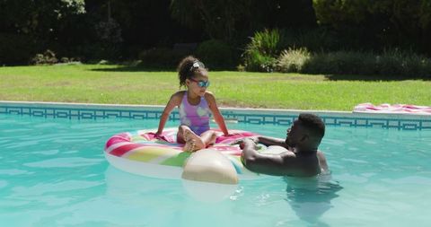Father and Daughter Enjoying Pool Time with Colorful Float