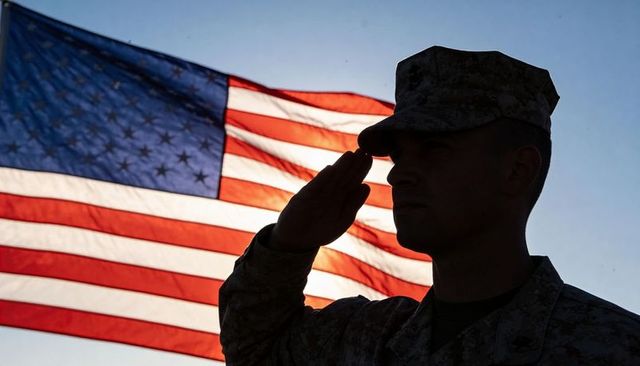 Soldier Saluting US Flag at Sunset Silhouette Backlit Military Uniformed Service Member
