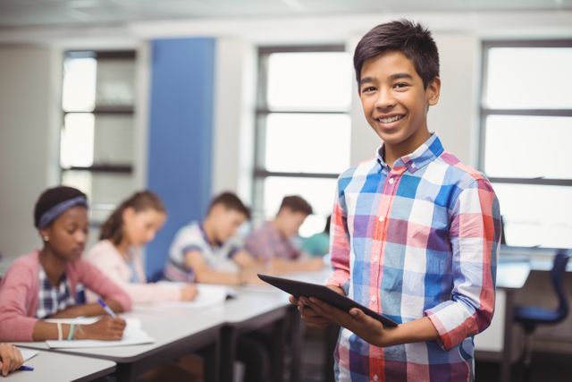 Schoolboy confidently giving a presentation in a classroom while holding a tablet. Other students are seated at desks, engaged in their work. Ideal for educational content, school-related articles, and technology in education themes.