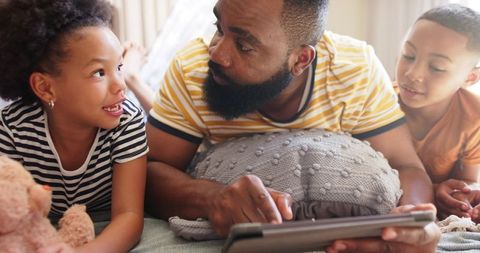Family Bonding: Father with Children Engaging on Tablet