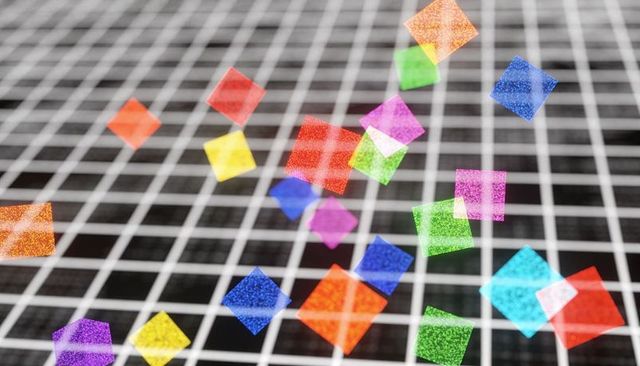 Iridescent glitter squares floating over bold black and white grid macro background