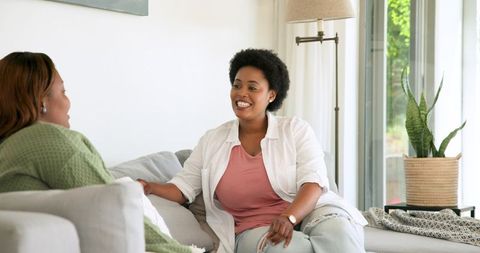 Smiling african american women chatting in cozy living room