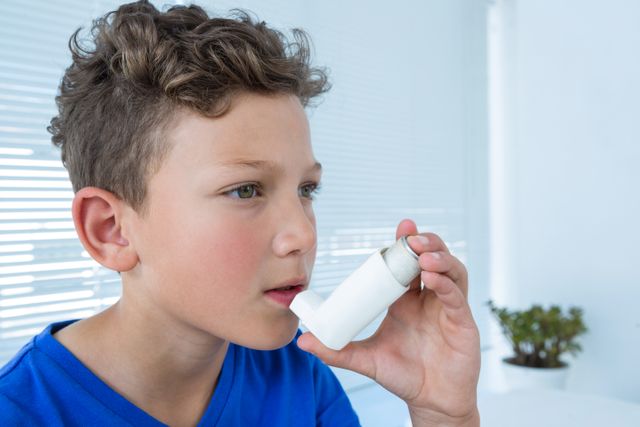 Young boy using asthma inhaler in a medical clinic. Ideal for illustrating pediatric healthcare, respiratory treatments, asthma awareness, and medical care for children. Can be used in health-related articles, medical brochures, and educational materials about asthma and respiratory conditions.