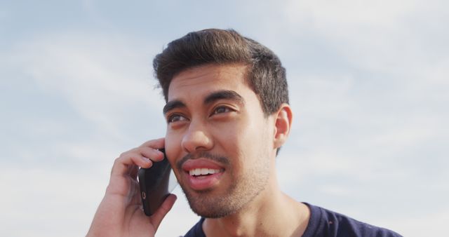 Smiling Young Man Making Phone Call Against Clear Sky Background - Download Free Stock Images Pikwizard.com