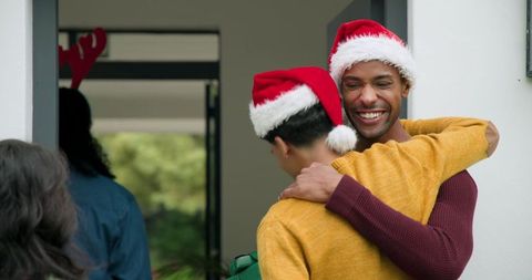 Friends Embrace in Holiday Spirit at Doorway