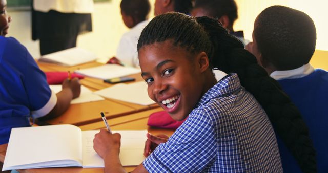 Smiling Student Writing in Classroom with Peers - Download Free Stock Images Pikwizard.com