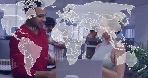 Global Team Collaborating Over Laptop with World Map Overlay in Modern Open Office