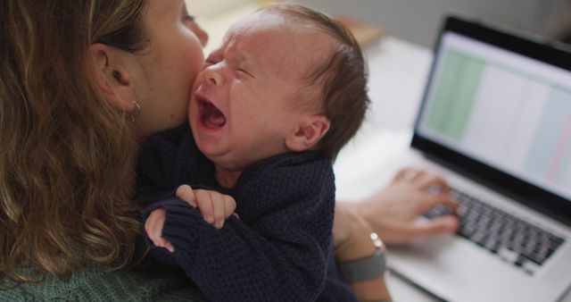 Image of caucasian mother working on laptop from home with newborn baby. motherhood, parental love and taking care of newborn baby concept digitally generated image.