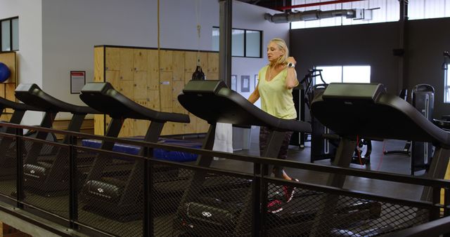 Woman walking on treadmill in empty gym - Download Free Stock Images Pikwizard.com