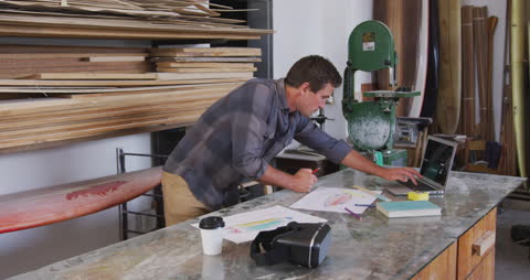 Surfboard Maker Designing Board in Studio Workshop