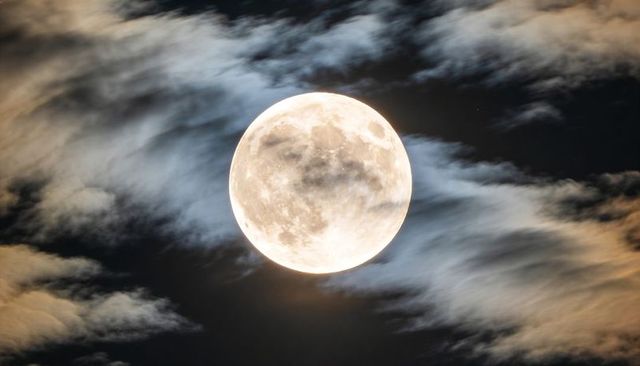 Glowing Full Moon Casting Halo Through Wispy Night Clouds with Lunar Detail