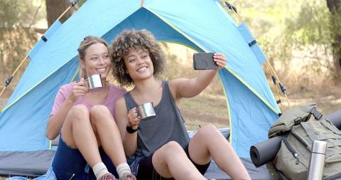 Two friends enjoying camping and taking a selfie