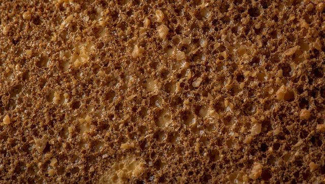 Macro toasted brown bread crumb texture with butter flecks closeup for food backgrounds