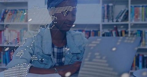 Teen studying with laptop in library with digital world map overlay for global learning