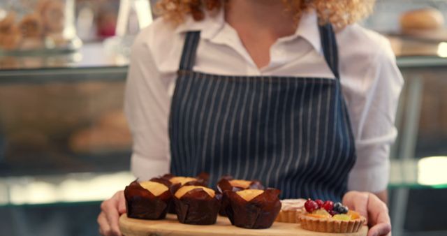 Bakery Worker Holding Freshly Made Muffins and Fruit Tart - Download Free Stock Images Pikwizard.com