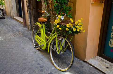 Vintage Bicycle with Yellow Daisies on Cobblestone Street