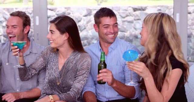 Group of friends having fun and enjoying cocktails together indoors. Perfect for illustrating social gatherings, celebrations, parties, friendship, and leisure activities.