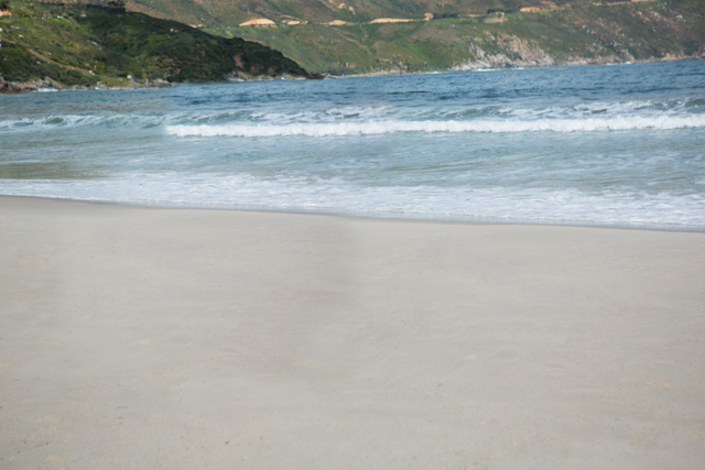 Calm Beach Shoreline with Transparent Blue Waters and Scenic Hills - Download Free Stock Videos Pikwizard.com