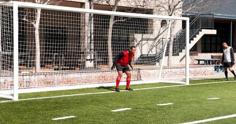 Determined soccer goalkeeper preparing to defend goal