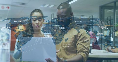 Business colleagues analyzing global data on laptop