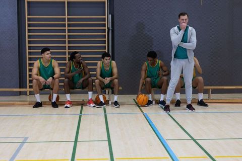 Basketball Team Engaged in Game Strategy Discussion on Bench