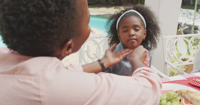 Mother Gently Feeding Daughter at Outdoor Table - Download Free Stock Images Pikwizard.com