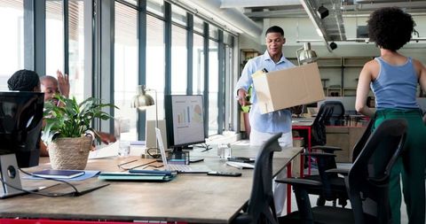 Team Welcoming New Colleague with Personal Items in Modern Office