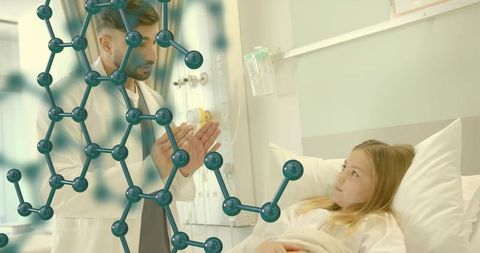 Pediatric clinician explaining molecular model to child patient in hospital bed