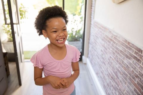 Happy African American Girl Standing in Bright Entryway