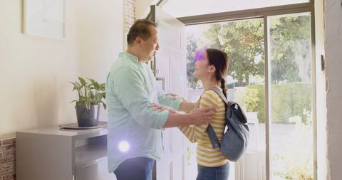 Father embracing daughter at front door returning home after school warm family welcome