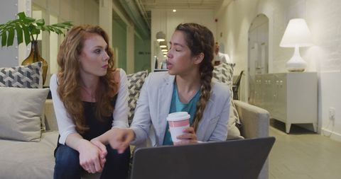 Businesswomen Collaborating on Sofa in Modern Office