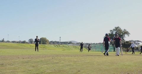 Cricket players training on sunny field for upcoming match