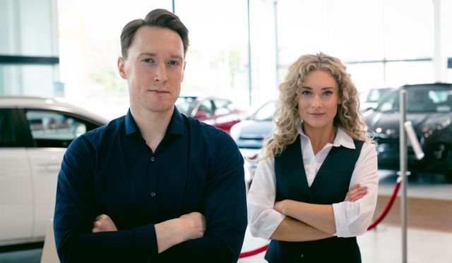 Portrait of entrepreneurs standing in car showroom - Download Free Stock Photos Pikwizard.com