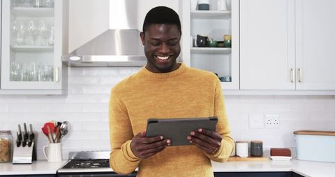 Man Smiling in Modern Kitchen Holding Digital Tablet