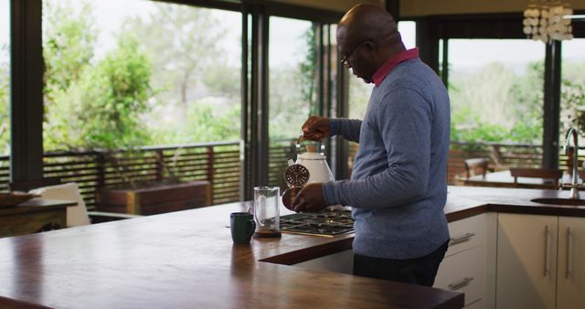 Man Preparing Coffee in Modern Kitchen with Garden View - Download Free Stock Images Pikwizard.com