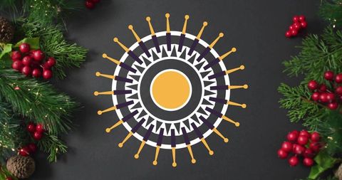 Decorating festive mandala ornament on charcoal tabletop with pine sprigs and red berries