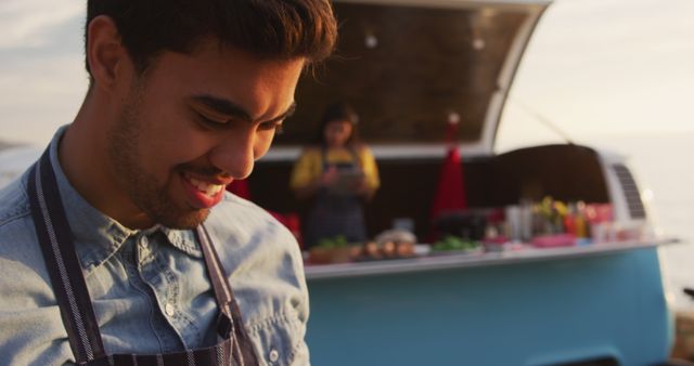 Smiling Food Truck Vendor Preparing Fresh Dishes at Sunset - Download Free Stock Images Pikwizard.com