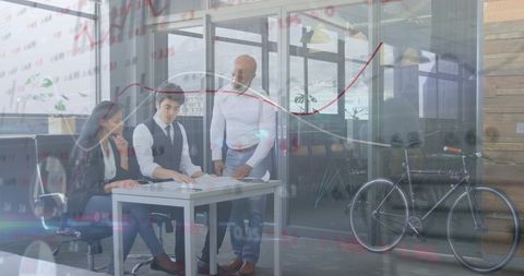 Reviewing financial charts and collaborating on strategy in modern glass office