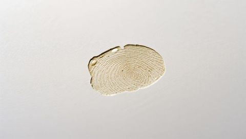 Macro amber droplet with concentric rings and fingerprint texture on white surface