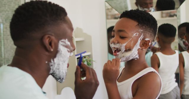 African american father and son shaving together. staying at home in self isolation during quarantine lockdown.